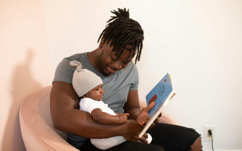 a father reading a book to his baby